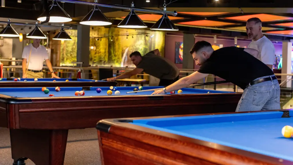 Freunde spielen gemeinsam Billard an mehreren Tischen im Restaurant CHILLY in St. Johann im Pongau