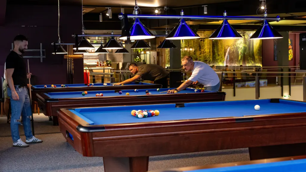 Freunde spielen gemeinsam Billard an mehreren Tischen im Restaurant CHILLY in St. Johann im Pongau