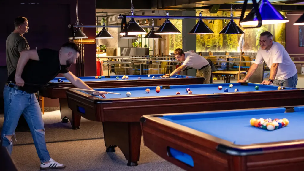 Mehrere Freunde spielen gemeinsam Billard an mehreren Tischen im Restaurant CHILLY in St. Johann im Pongau