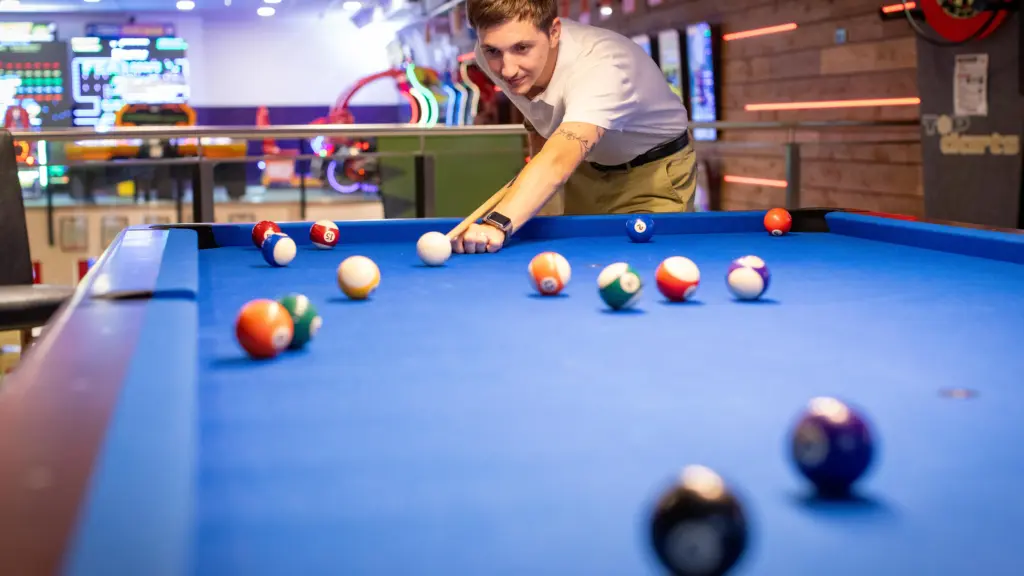 Junger Mann setzt zum Stoß an beim Billard im Restaurant CHILLY in St. Johann im Pongau