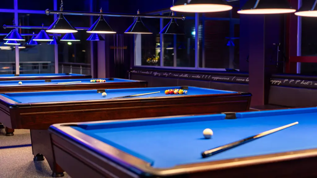 Billardraum mit mehreren Pooltischen und Billardlampen im Restaurant CHILLY in St. Johann im Pongau