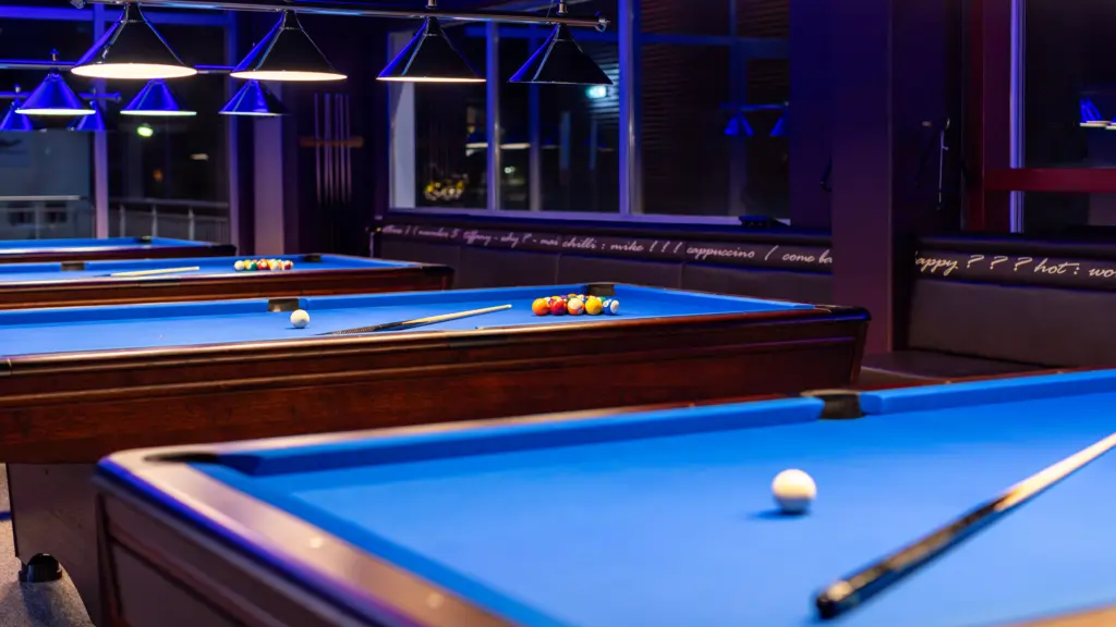 Billardraum mit mehreren Pooltischen und aufgebauten Kugeln im Restaurant CHILLY in St. Johann im Pongau